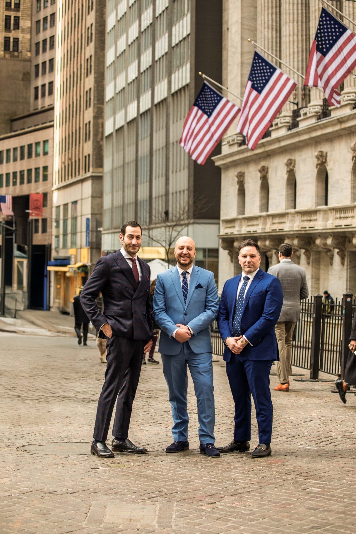 IX Legal partners standing in front of the New York Stock Exchange