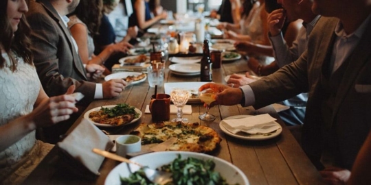 table with lots of food and people