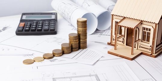 coins stacked next to house and calculator with documents underneath
