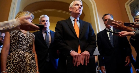 man speaking surrounded by other people