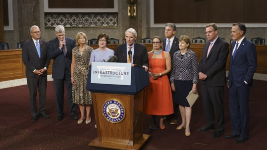 man speaking with people standing around him