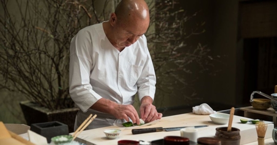 man making sushi